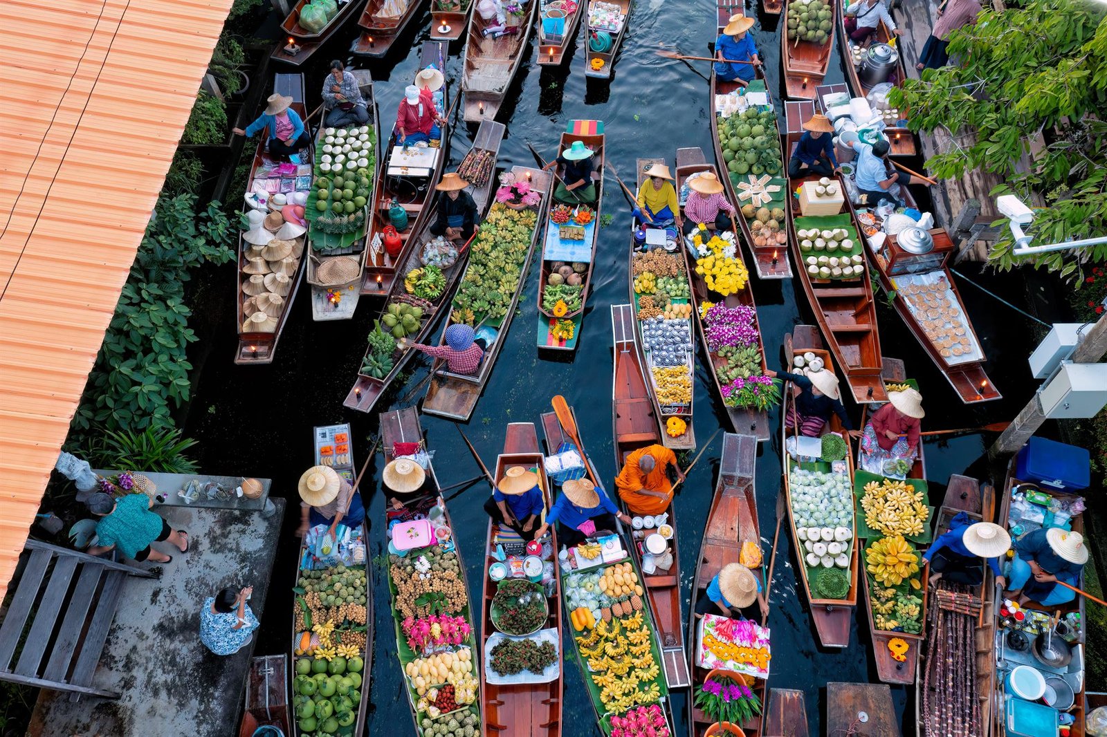 Aerial view of a floating market in central Thailand, longtail boats loaded with fruit and flowers