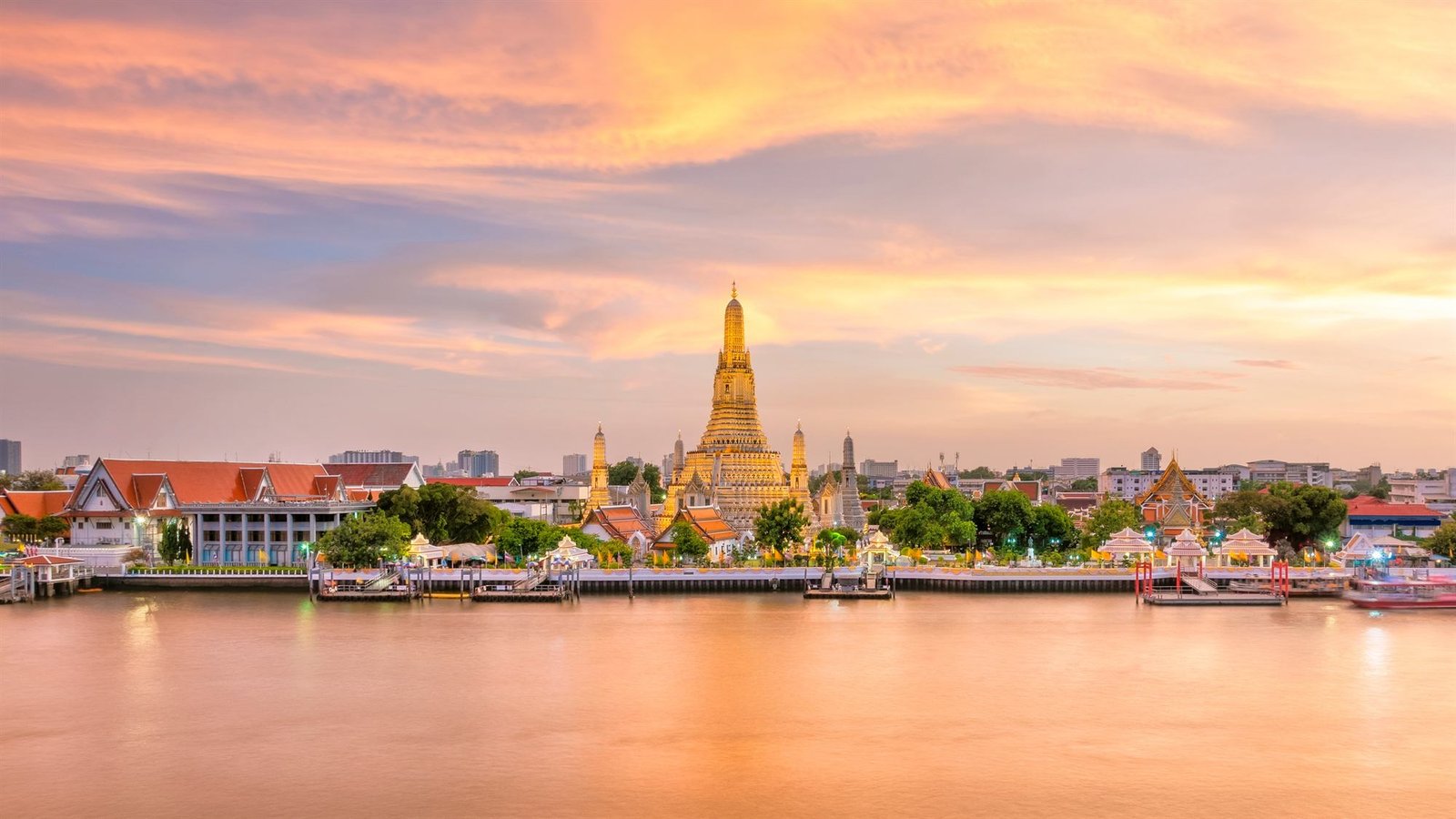 Wat Arun lit at sunset across the Chao Phraya river in Bangkok