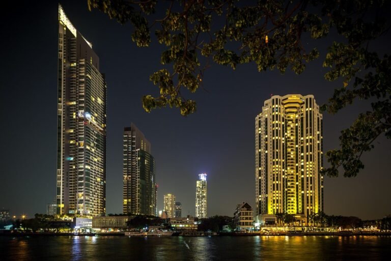 The Chao Phraya at night, towers along the riverbank