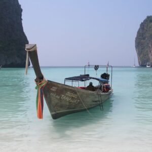 A longtail moored in Maya Bay under the cliffs of Phi Phi Leh